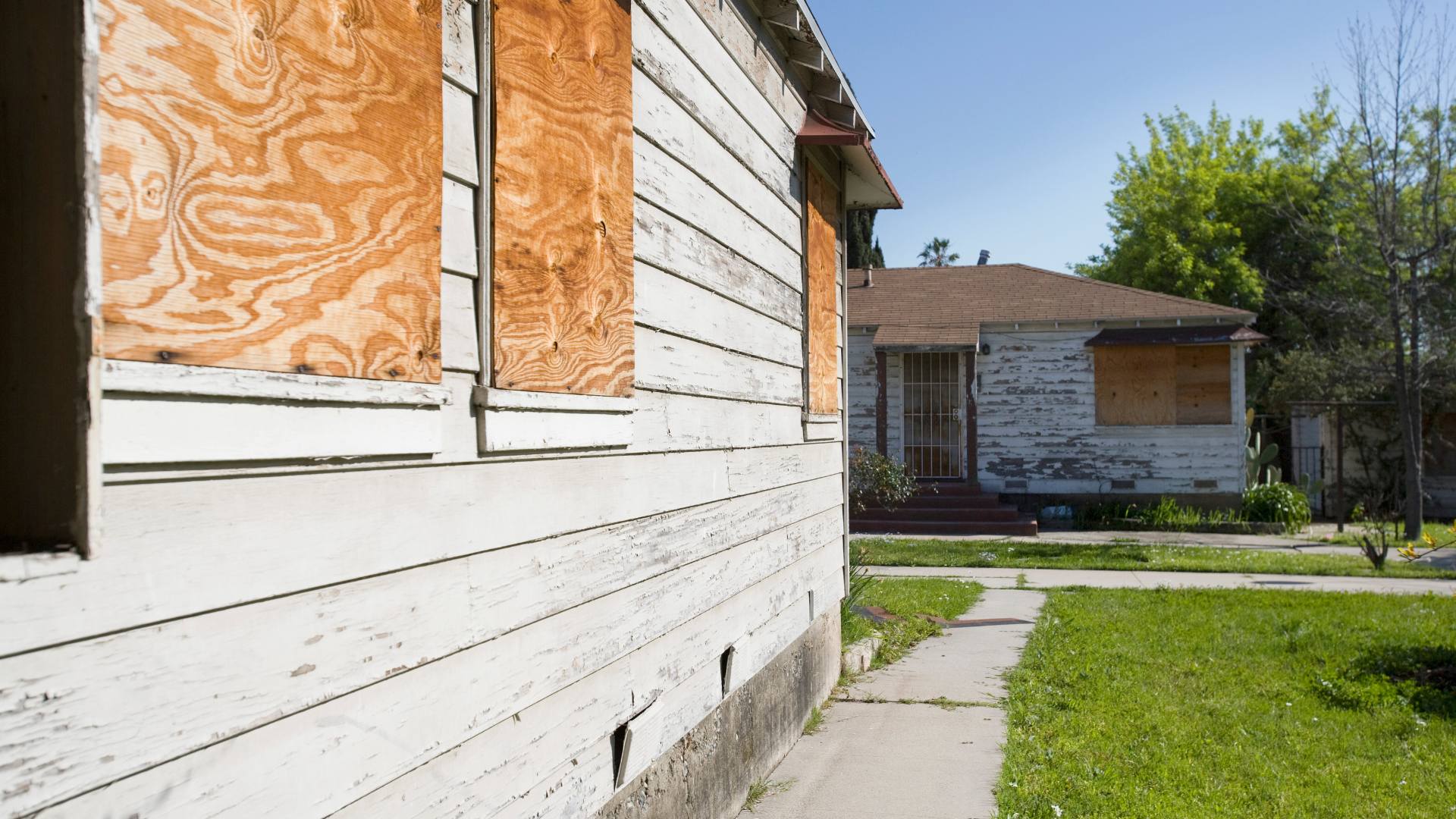 Commercial building boarded up with plywood after glass damage
