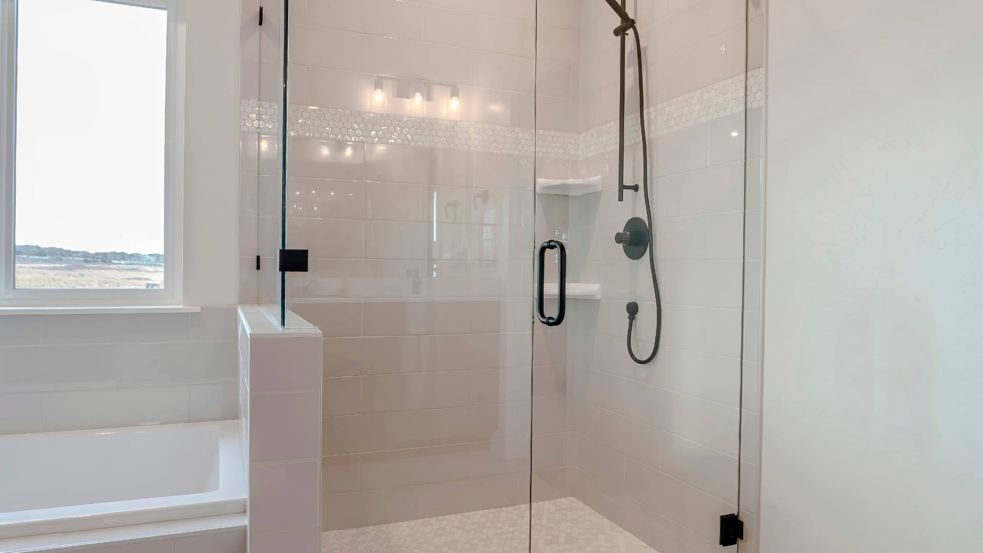 Frameless glass shower enclosure in a luxury marble bathroom