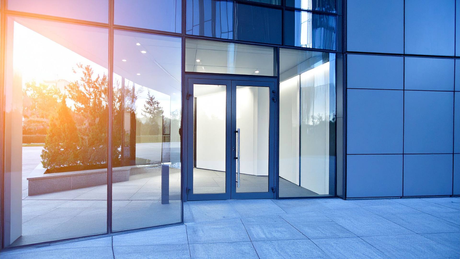 Glass building facade reflecting golden-hour sunlight
