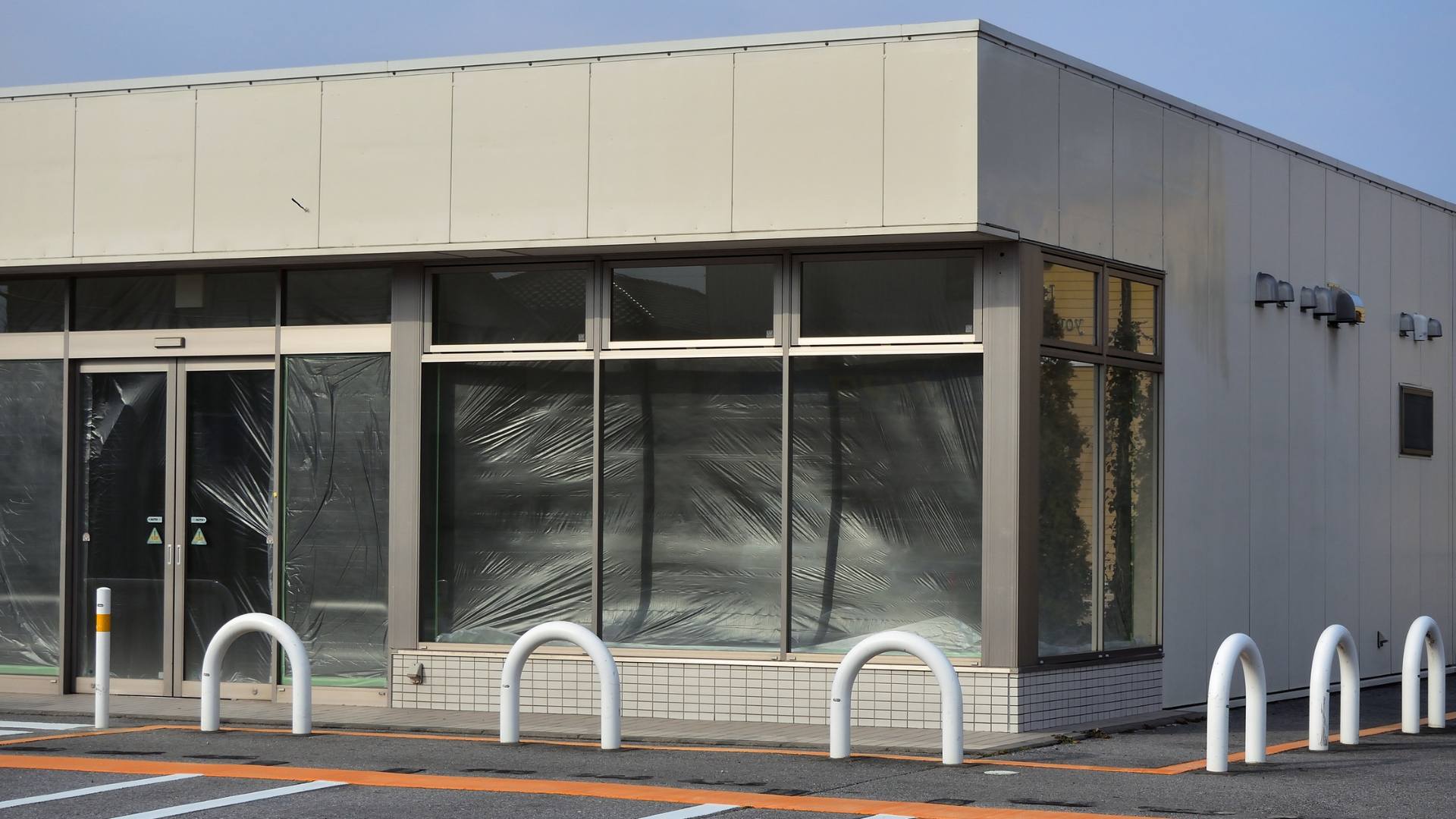 Minimalist storefront with clean glass and metal bollards