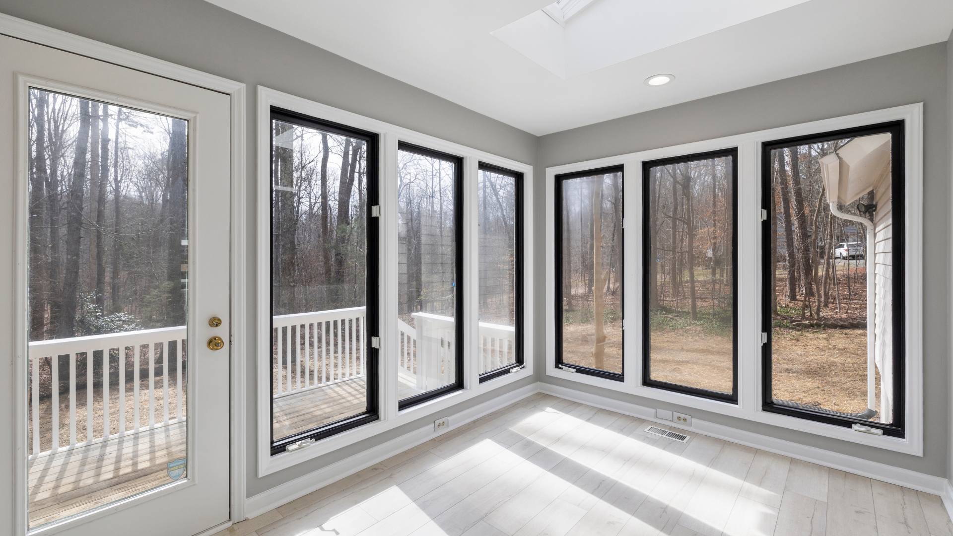 Sunroom with multiple glass doors opening to nature