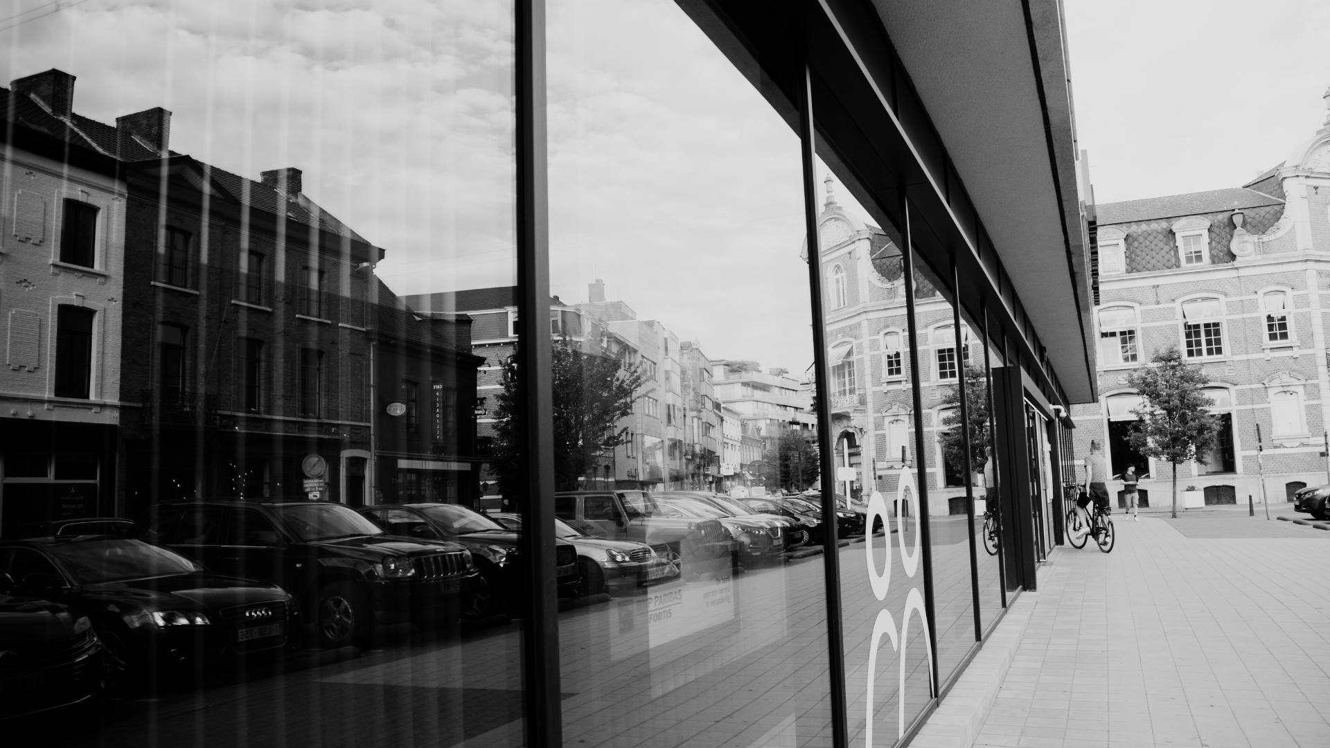 Urban storefront glass reflecting the street